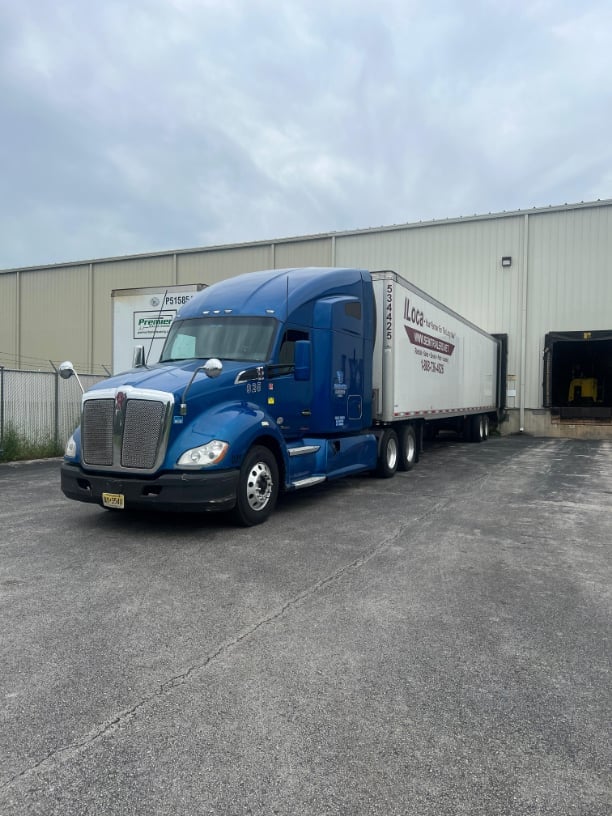 Blue Kenworth semi truck fleet at loading dock